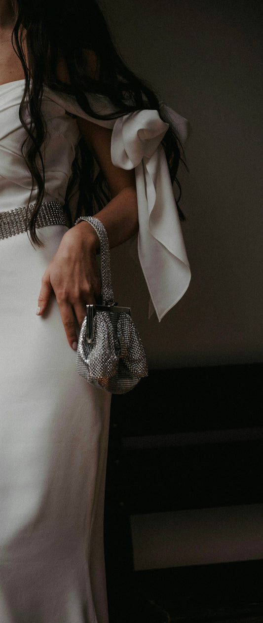 a woman in a white dress holding a purse