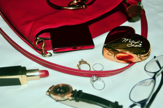 a purse, lipstick, glasses and other items on a table