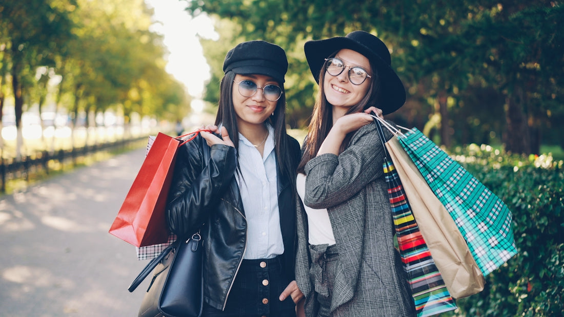 Two women with shopping bags in a park