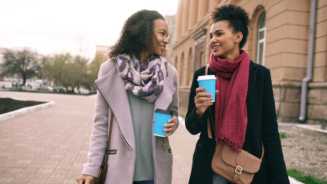 Two women walking with coffee cups
