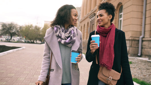 Two women walking with coffee cups