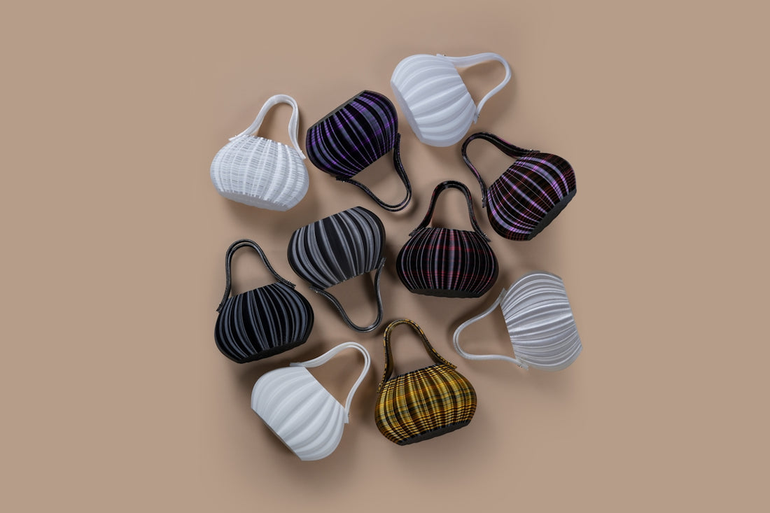 Collection of small, colorful, pleated handbags arranged on a surface.